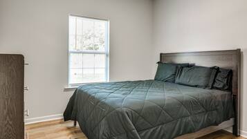 Un dormitorio con una cama, una ventana y una puerta.