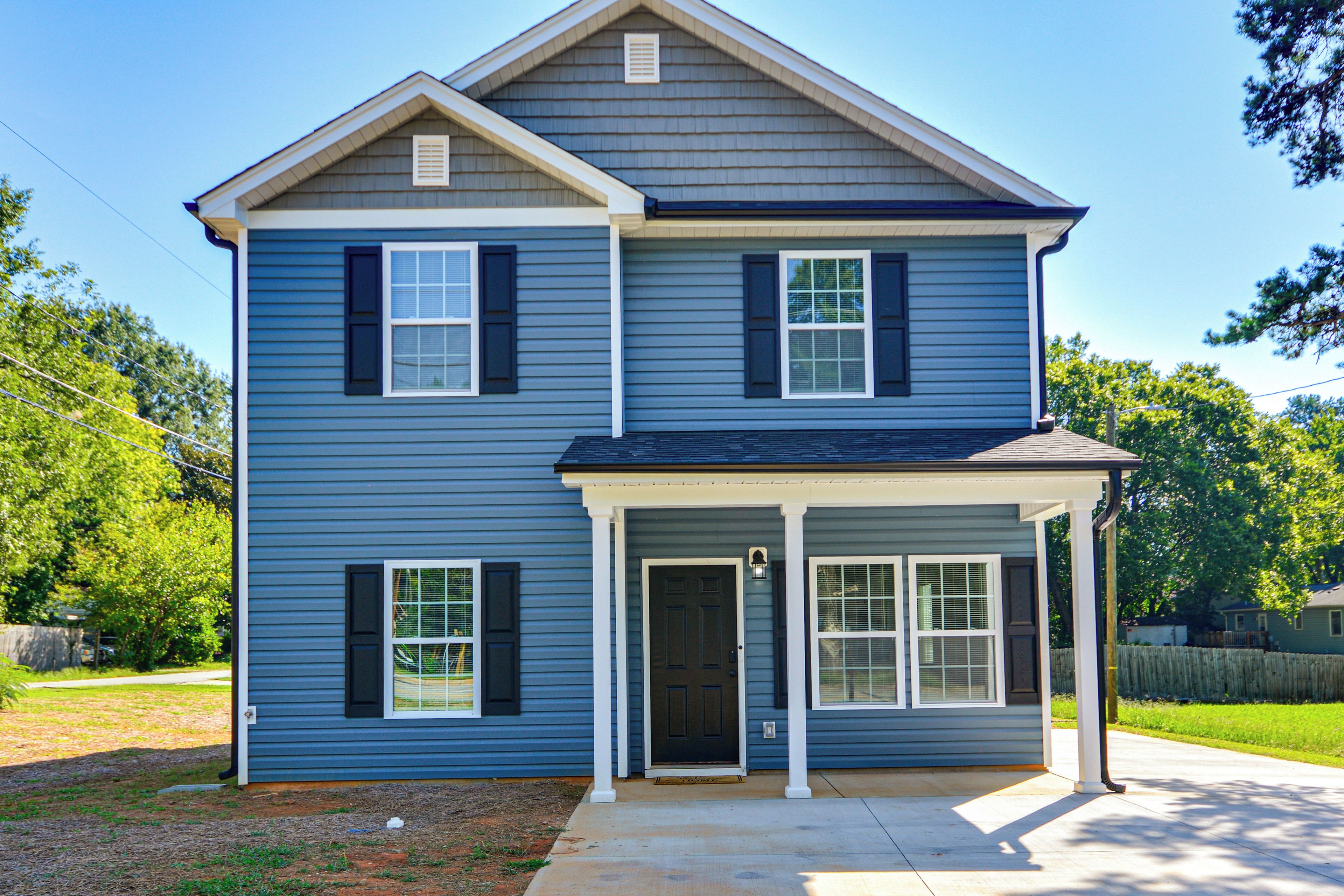 A two-story house with a front porch, a garage, and a covered entryway.