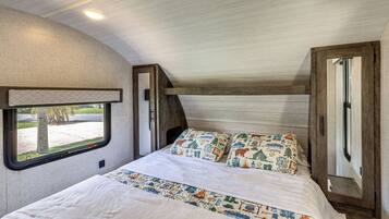 Un dormitorio con una cama, una ventana y una puerta.