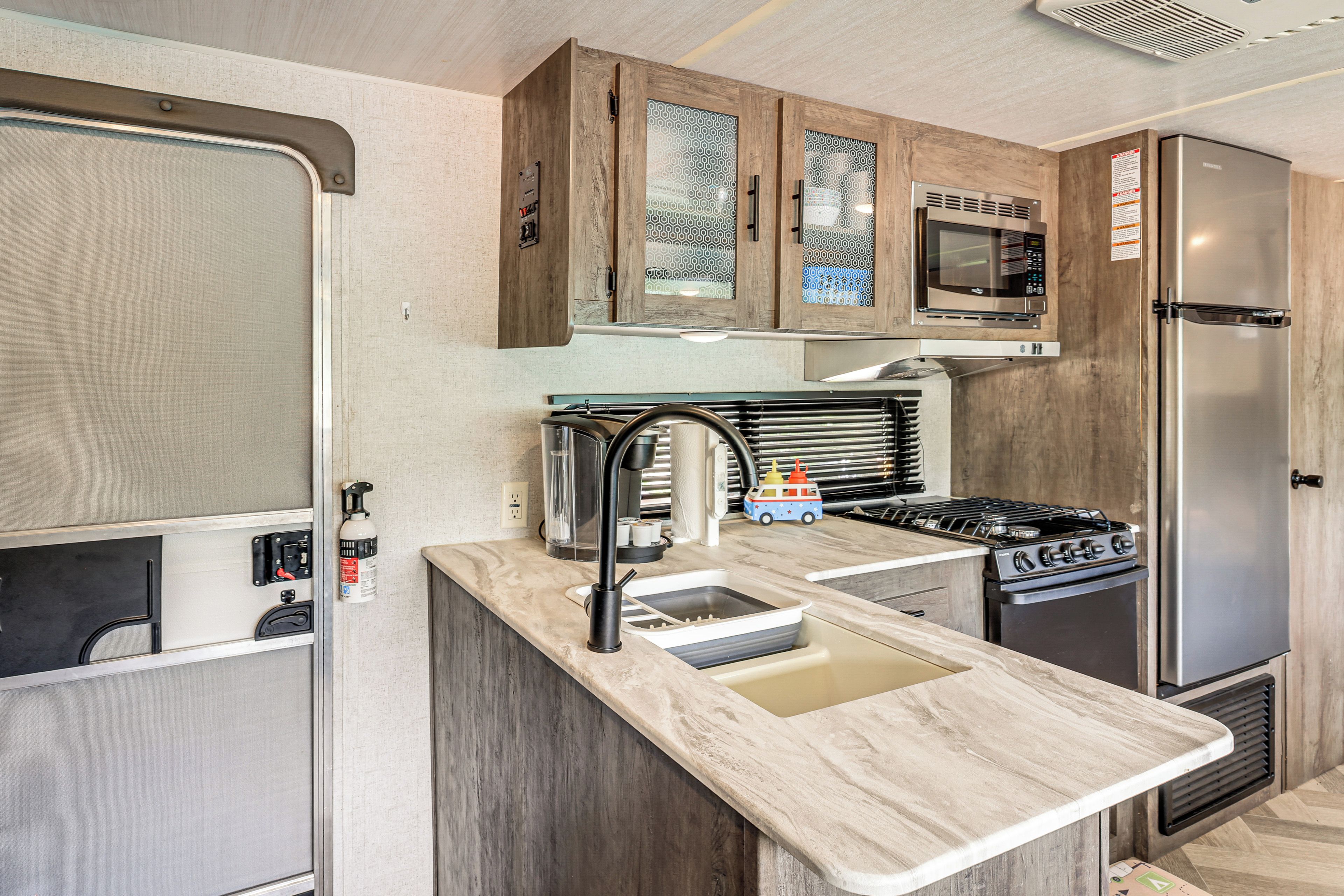 Una cocina compacta con estufa integrada, microondas y refrigerador.