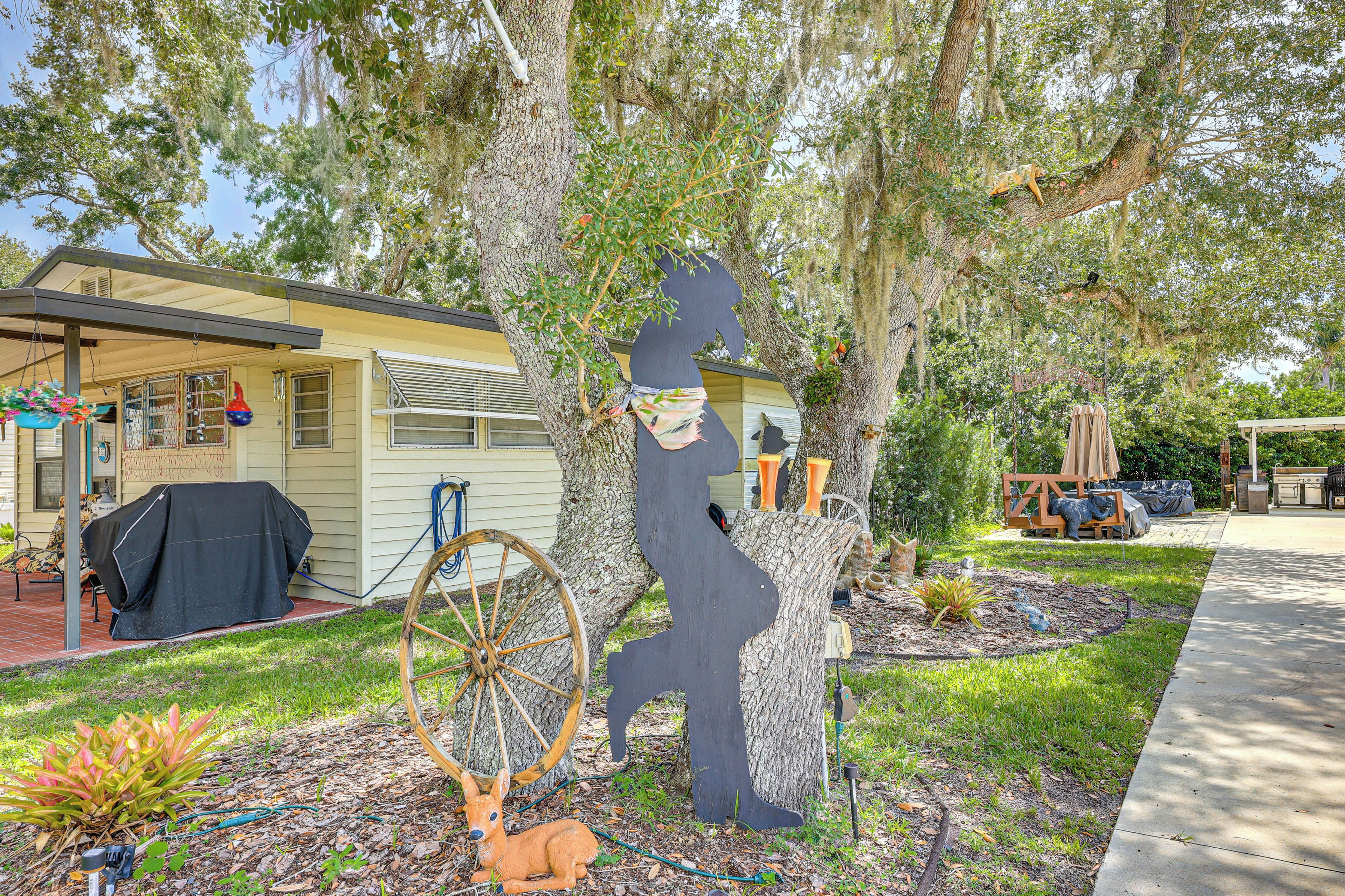 A residential property with a covered patio, a barbecue area, and a garden with decorative items.
