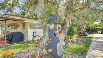 A residential property with a covered patio, a barbecue area, and a garden with decorative items.