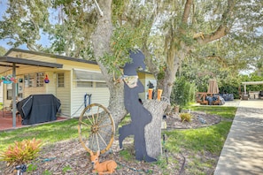 A residential property with a covered patio, a barbecue area, and a garden with decorative items. - River Ranch RV Retreat w/ Pool & Hot Tub Access (River Ranch)