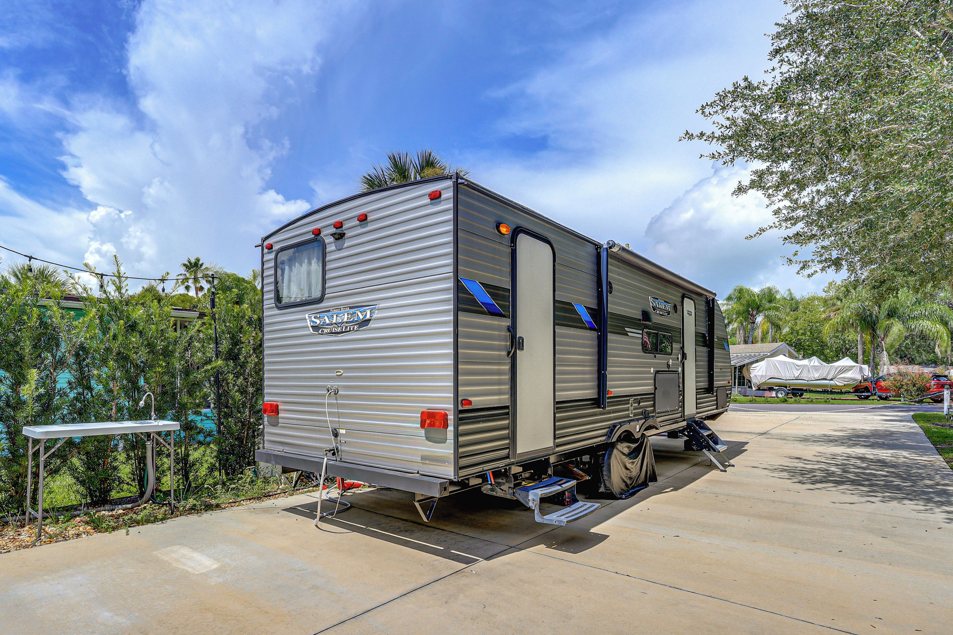 A stationary RV with a visible kitchen area, a sliding door, and a small window.