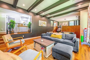 Ein modernes Wohnzimmer mit einer Eckcouch, Holzböden und einer Treppe zu einer oberen Ebene.