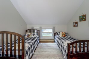 Ein Zimmer mit zwei Betten, einem Fenster und Blick ins Freie.