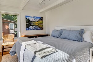 Un dormitorio con una cama grande, vistas al exterior y un cuadro en la pared.