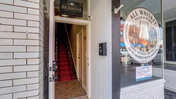 A hotel entrance with a sign for 'The Rickhouse Luxury Bourbon Loft' and a sign for 'All Whiskey Tells a Story.'