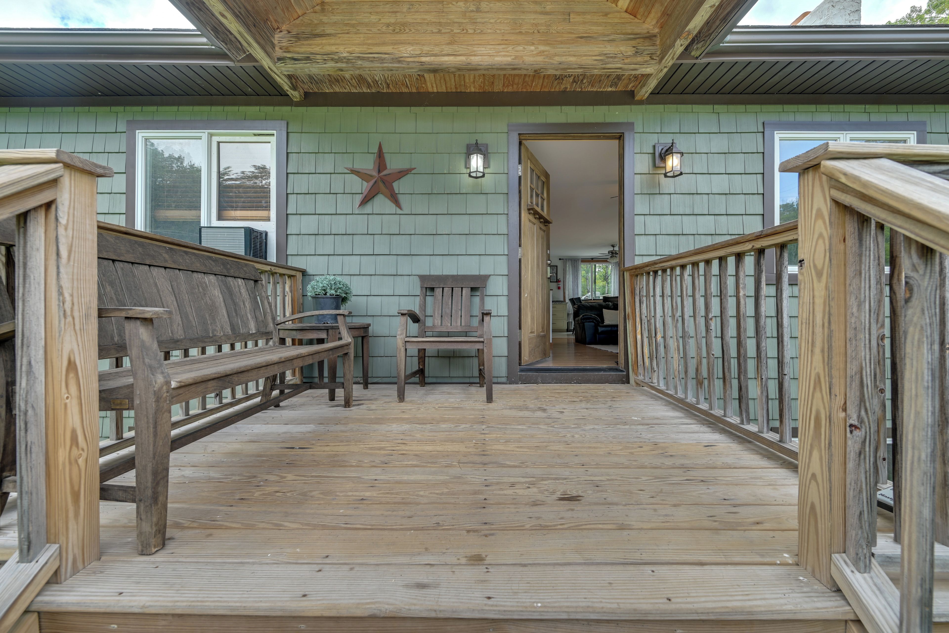 A wooden deck with a star decoration, a bench, and a chair.