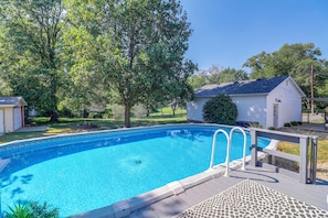 A clear blue swimming pool with a wooden deck and a metal ladder. - Fire Pit & Fenced Yard! Peaceful Glen Carbon Home (Glen Carbon)