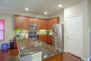 A modern kitchen with wooden cabinets, stainless steel appliances, and a granite countertop. - Lewisville Lake Escape, 4 Mi to Boat Ramp (Little Elm)