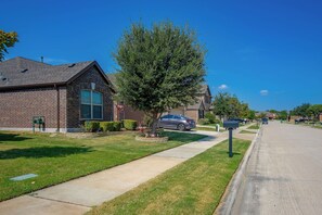 A residential street with houses, a sidewalk, and a clear blue sky. - Lewisville Lake Escape, 4 Mi to Boat Ramp (Little Elm)