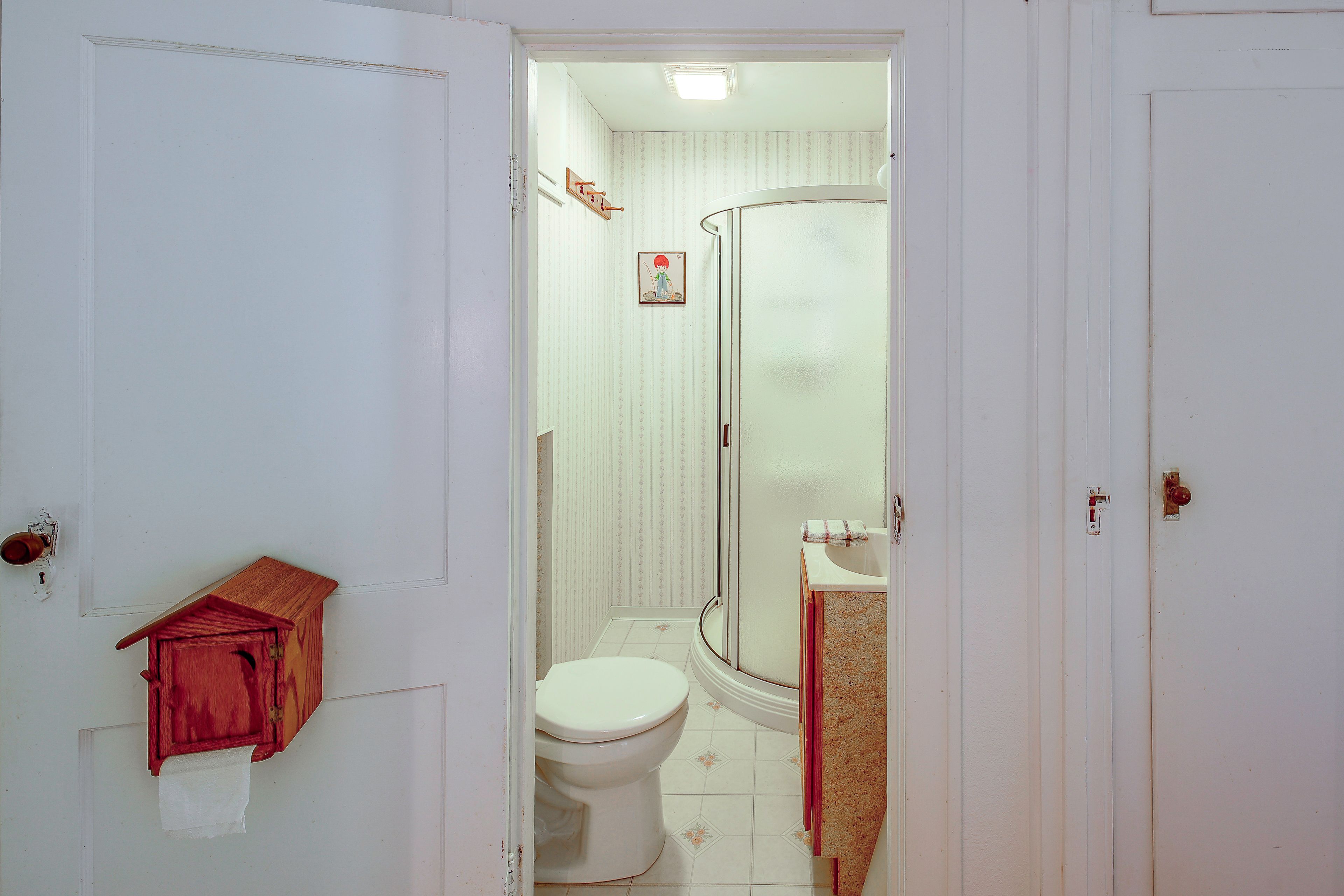 A bathroom with a toilet, a shower, and a sink.