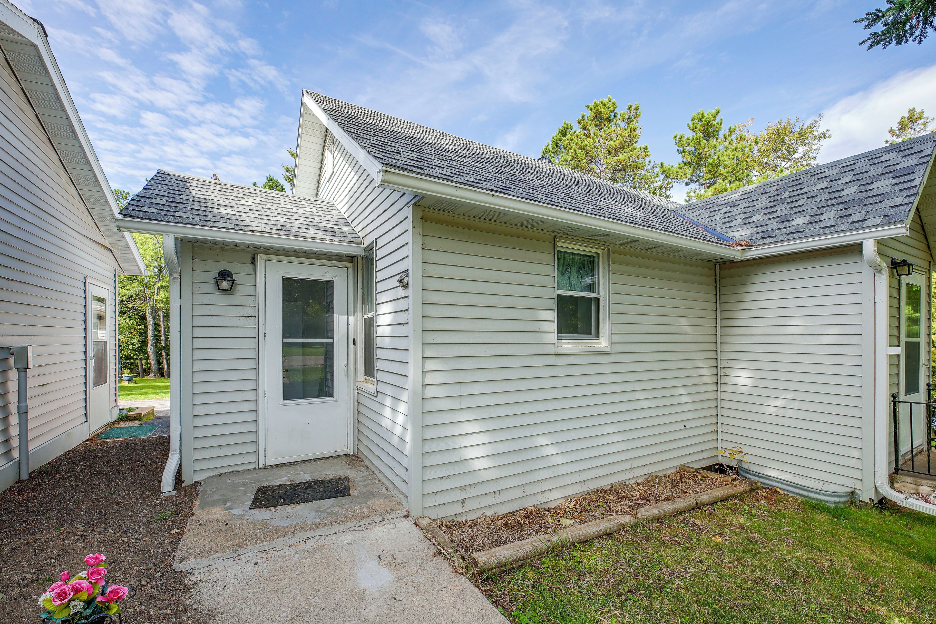 A single-story house with a front door, a small porch, and a visible window.