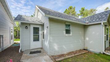 A single-story house with a front door, a small porch, and a visible window.