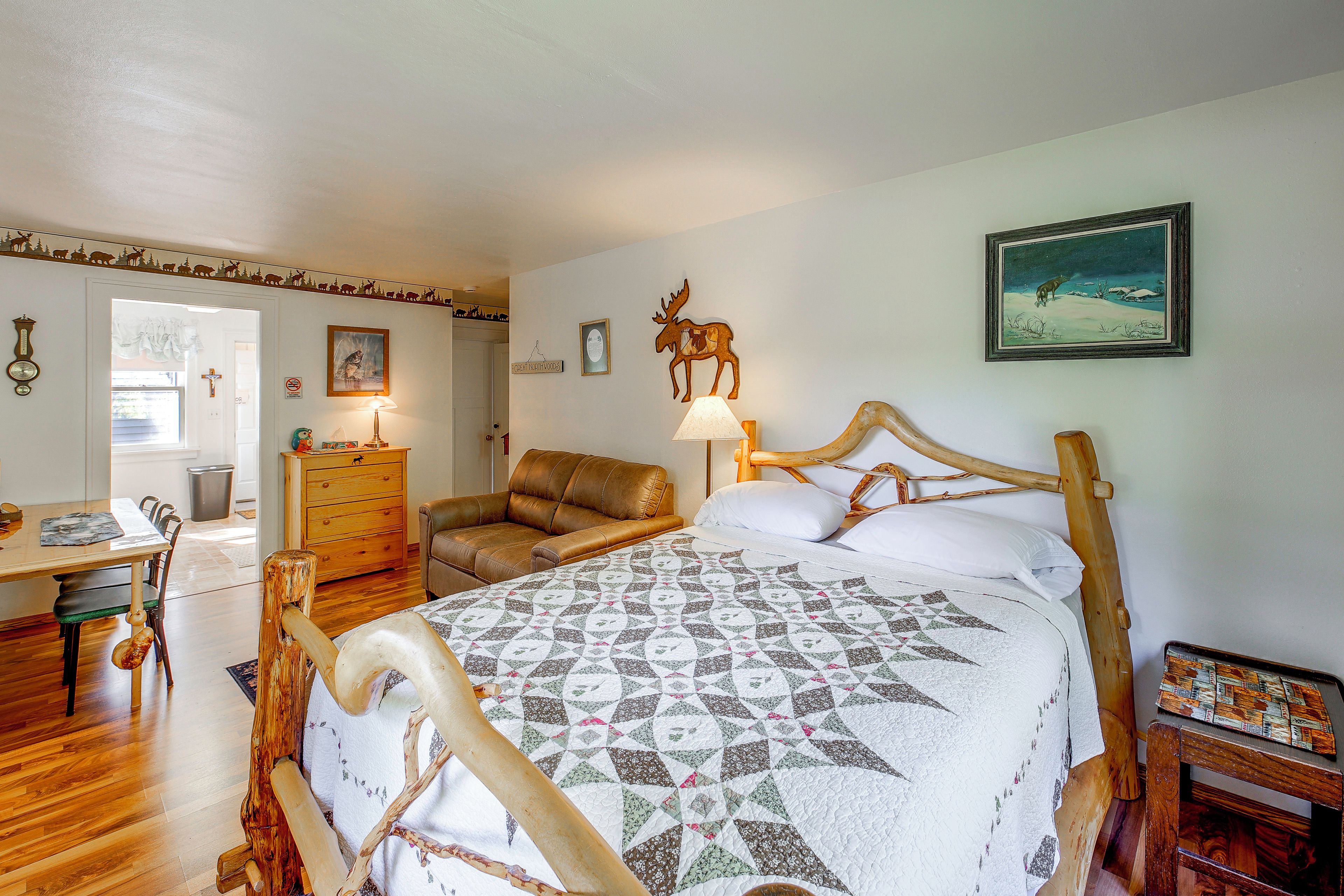 A bedroom with a bed, a chair, a desk, and a wall clock.