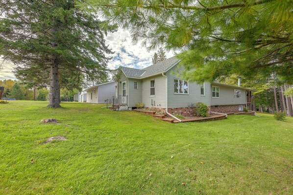 A two-story house with a sloped roof, a front porch, and a well-maintained lawn.