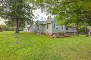 A two-story house with a sloped roof, a front porch, and a well-maintained lawn.