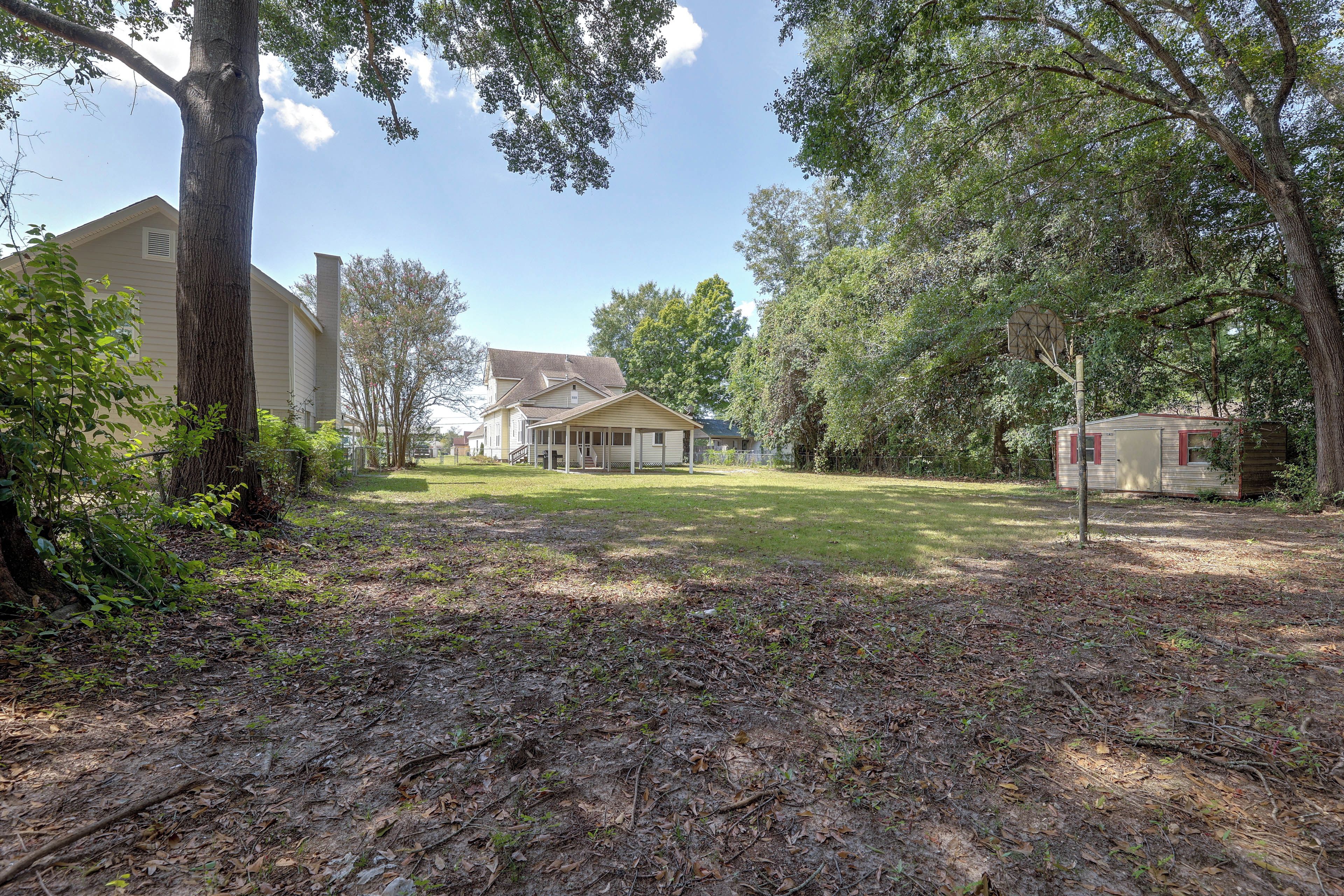 A residential area with a house, a garage, and a fenced yard.