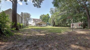 A residential area with a house, a garage, and a fenced yard.