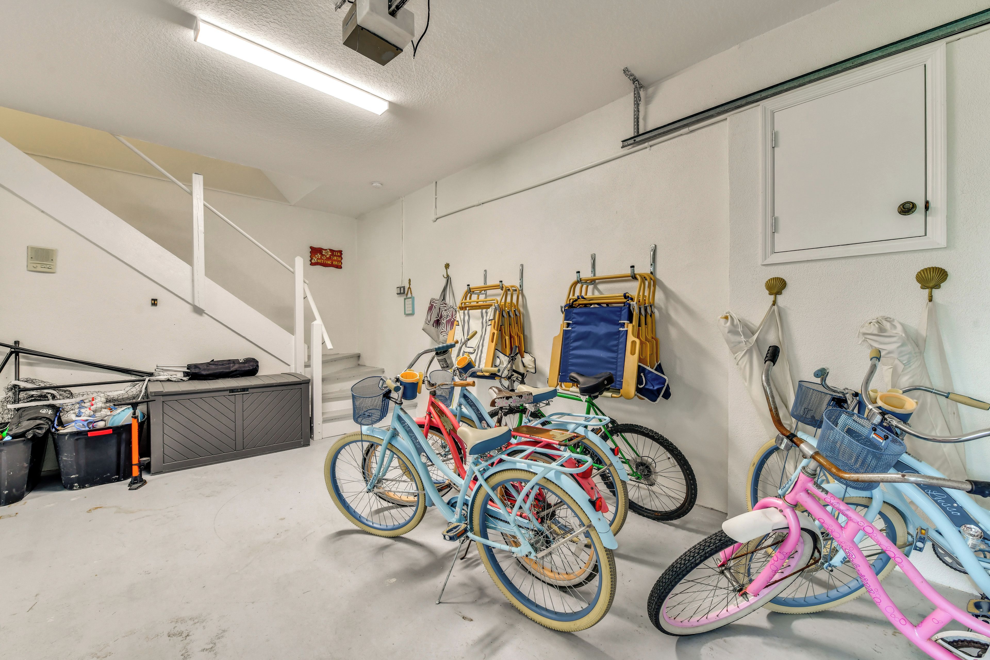 A multi-level indoor space with bicycles, a staircase, and various storage items.