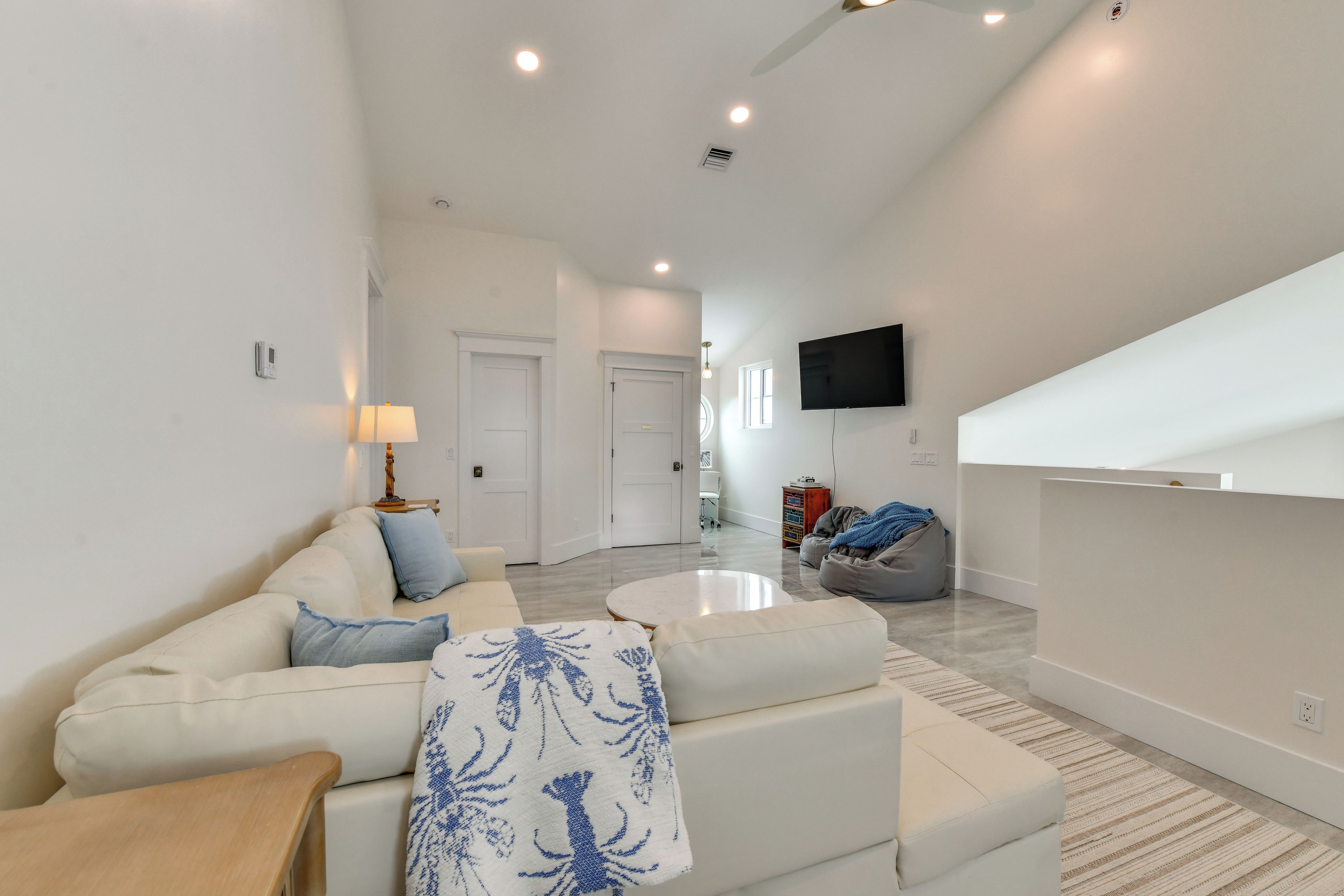 A modern living room with a sofa, ottoman, and a coffee table.