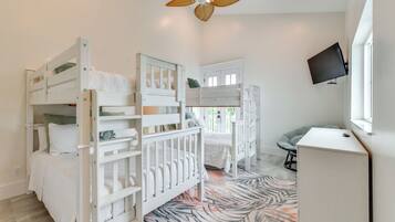 A children's room with bunk beds, a desk, and a television.