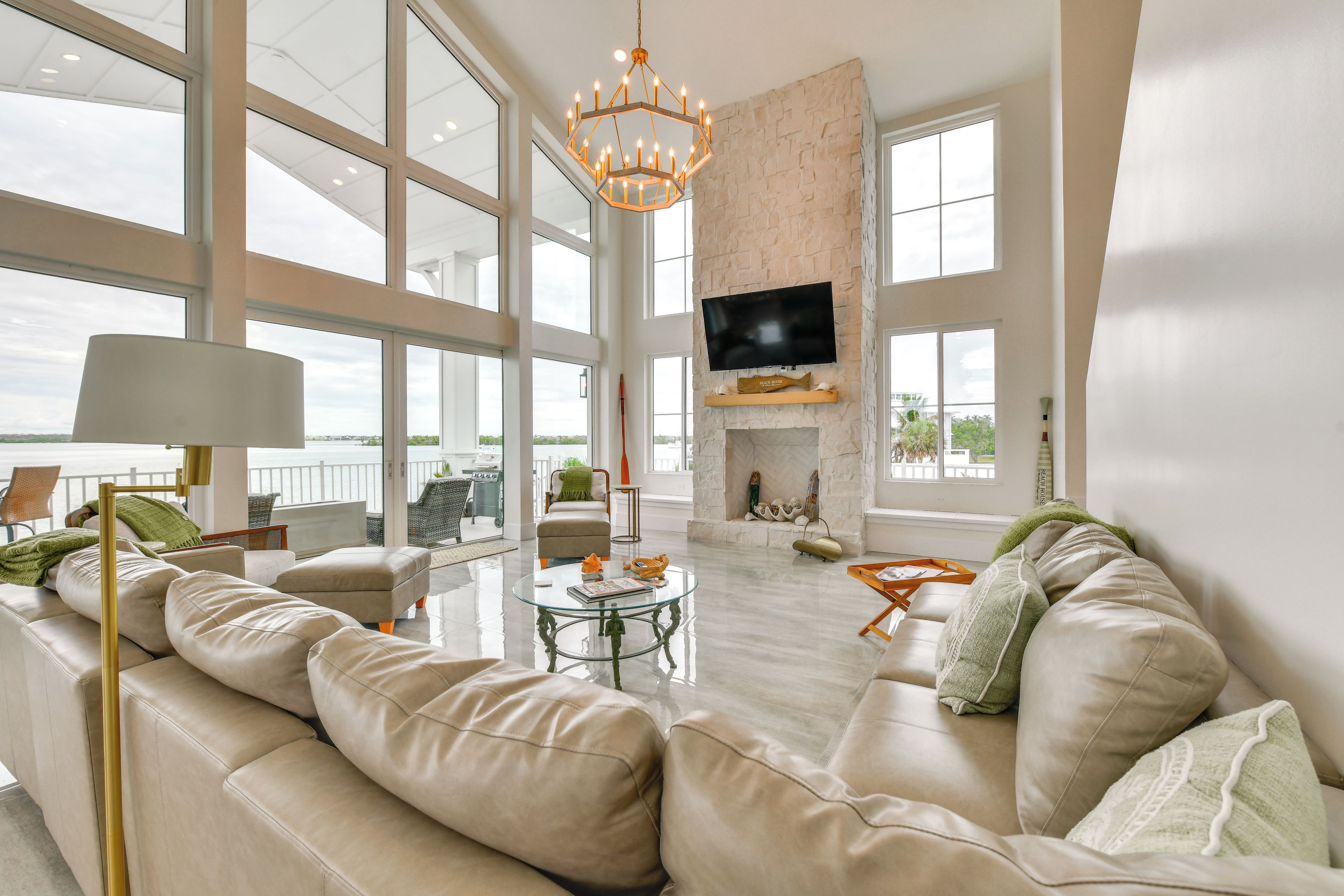 A spacious living room with a large sofa, a glass coffee table, and a fireplace.
