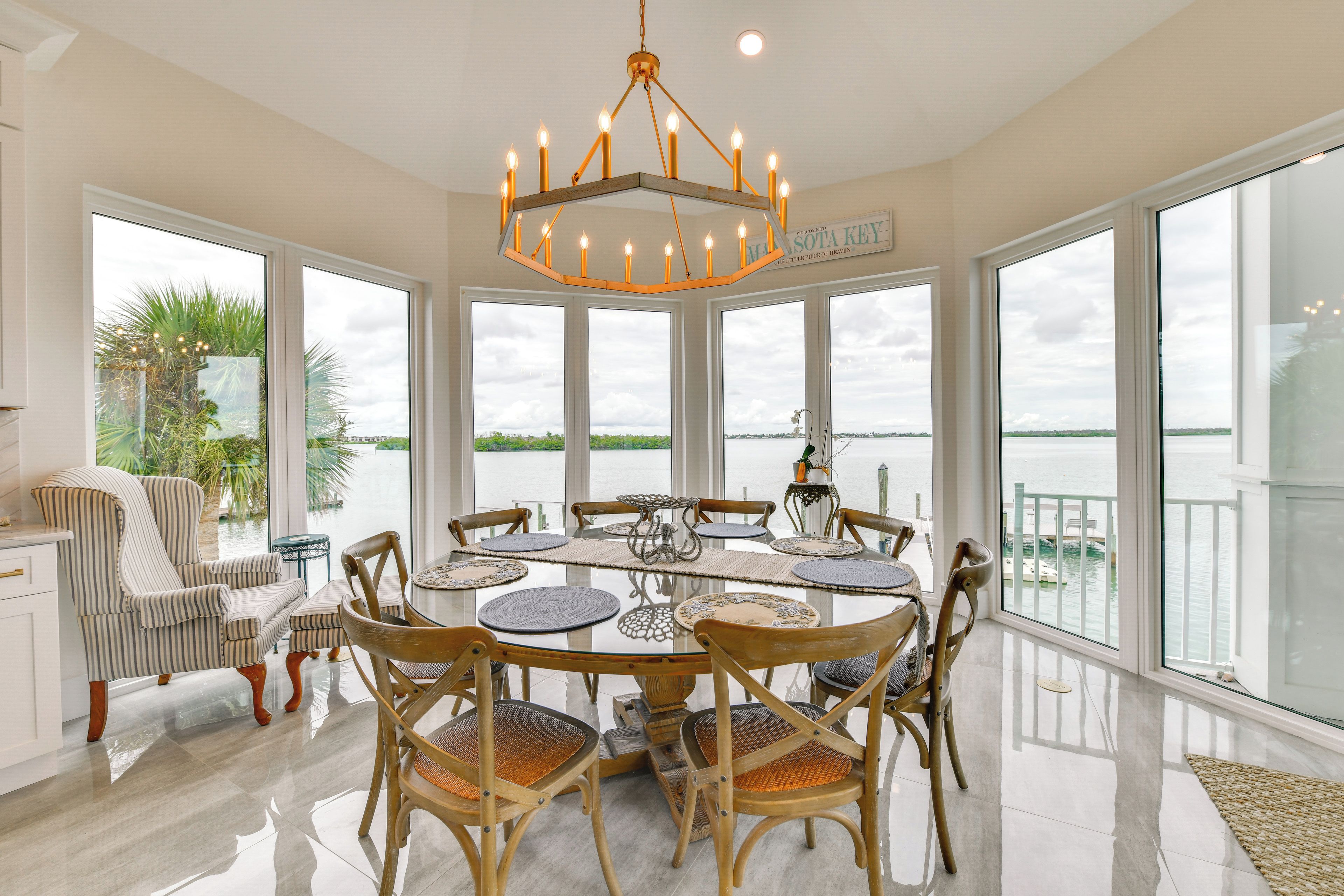A spacious dining area with a large table, chairs, and a chandelier.