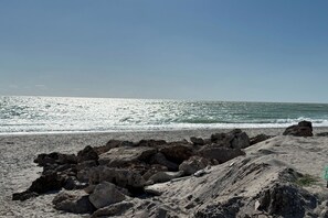 Een rotsachtige kust met golven die op het strand breken.