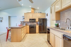 A modern kitchen with granite countertops, stainless steel appliances, and wooden cabinetry. - Panoramic Views! Clear Lake Cottage w/ Patio (Clearlake)