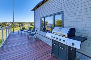 A deck with a grill and chairs, overlooking a scenic landscape. - Shorefront Maine Escape! Paddle, Hike & Stargaze (Harborside)