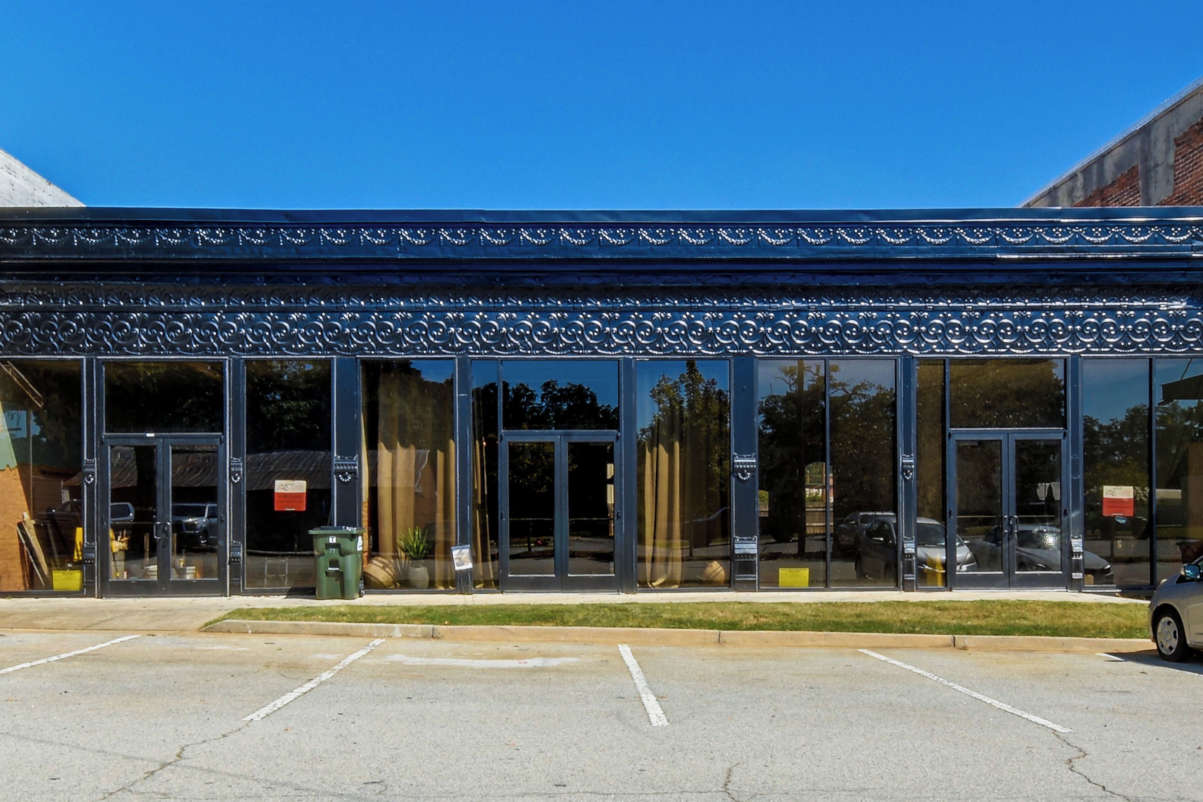 A building with a modern architectural style, featuring large glass windows and a metal awning.