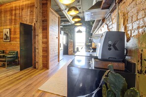 A modern interior with wooden walls, a black countertop, and a cactus plant. - Historic Loft of Comer! Walk to Shops & Dining (Comer)