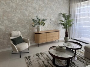 A modern living room with a sofa, a coffee table, a sideboard, and a potted plant. - Apartment 'Duplex Bahía' with shared pool, private terrace and Wi-Fi (Málaga)