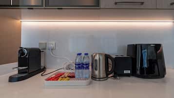 Una encimera de cocina con una cafetera, un hervidor y una tostadora.