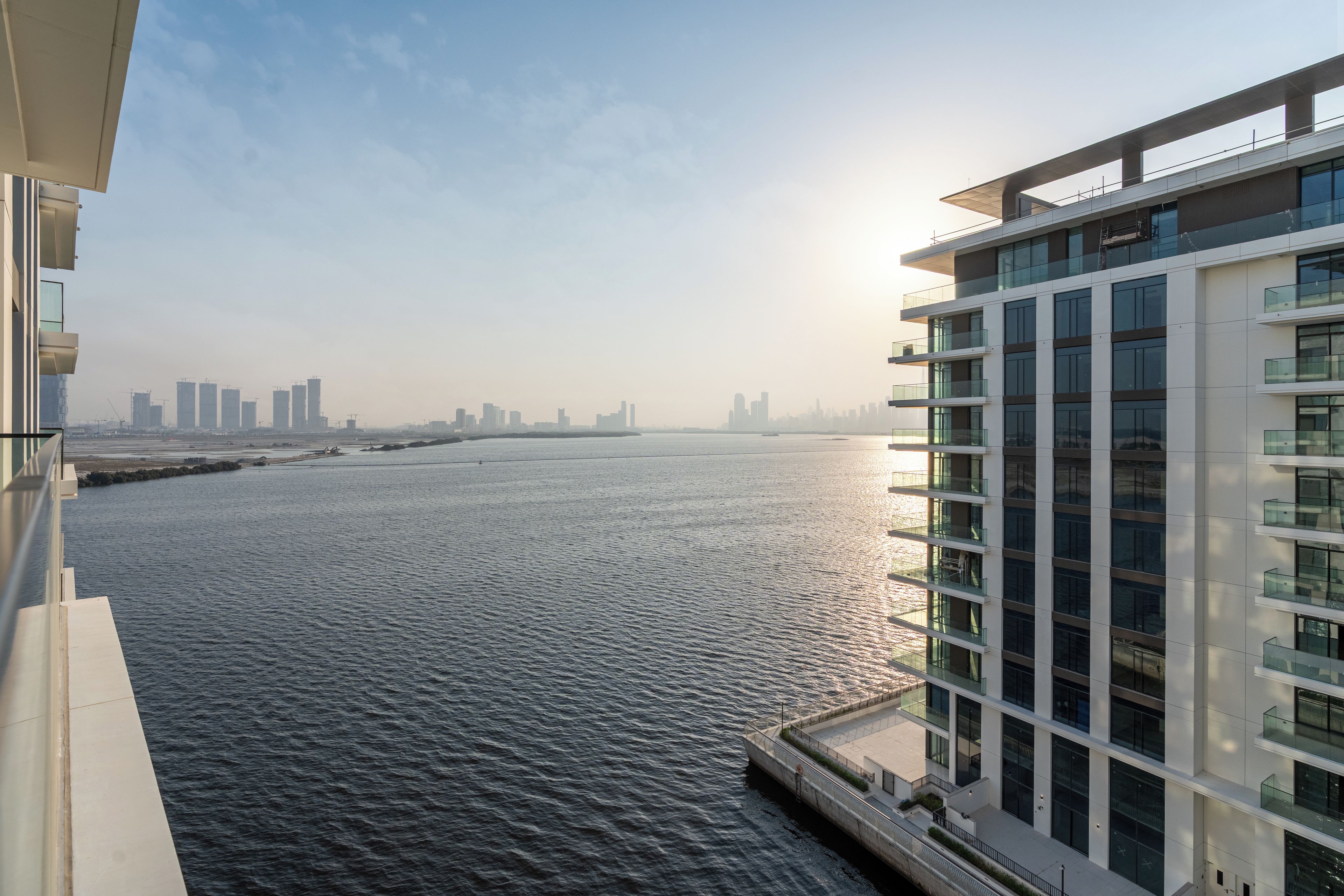 Un edificio alto con vistas a un río y un horizonte urbano lejano.