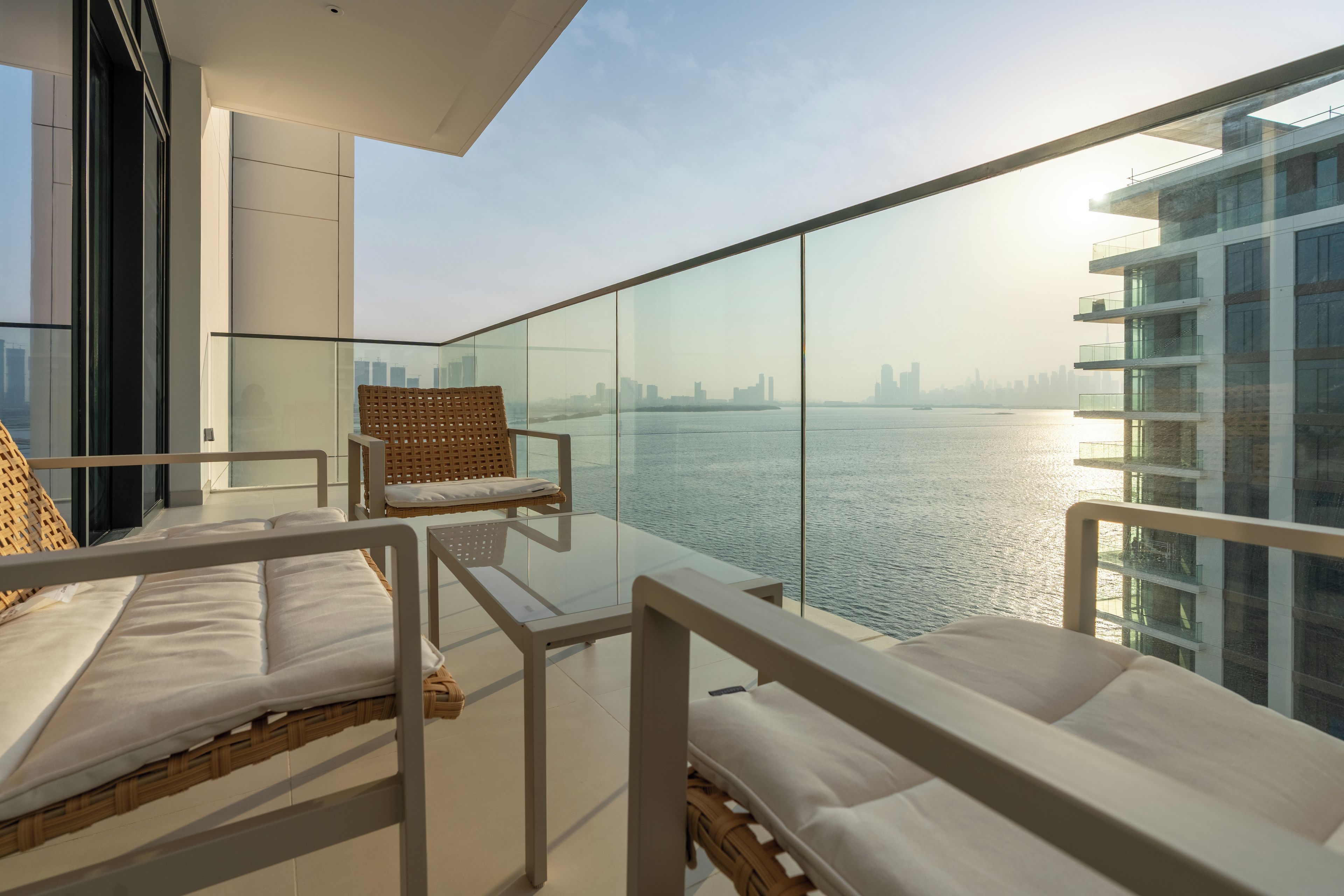 A balcony with a view of a city skyline and a body of water.