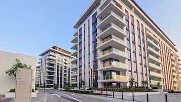 Un immeuble résidentiel moderne à plusieurs étages, avec un ciel dégagé.