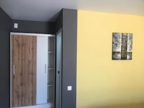 Una habitación con armario, una puerta y una obra de arte colgada en la pared.