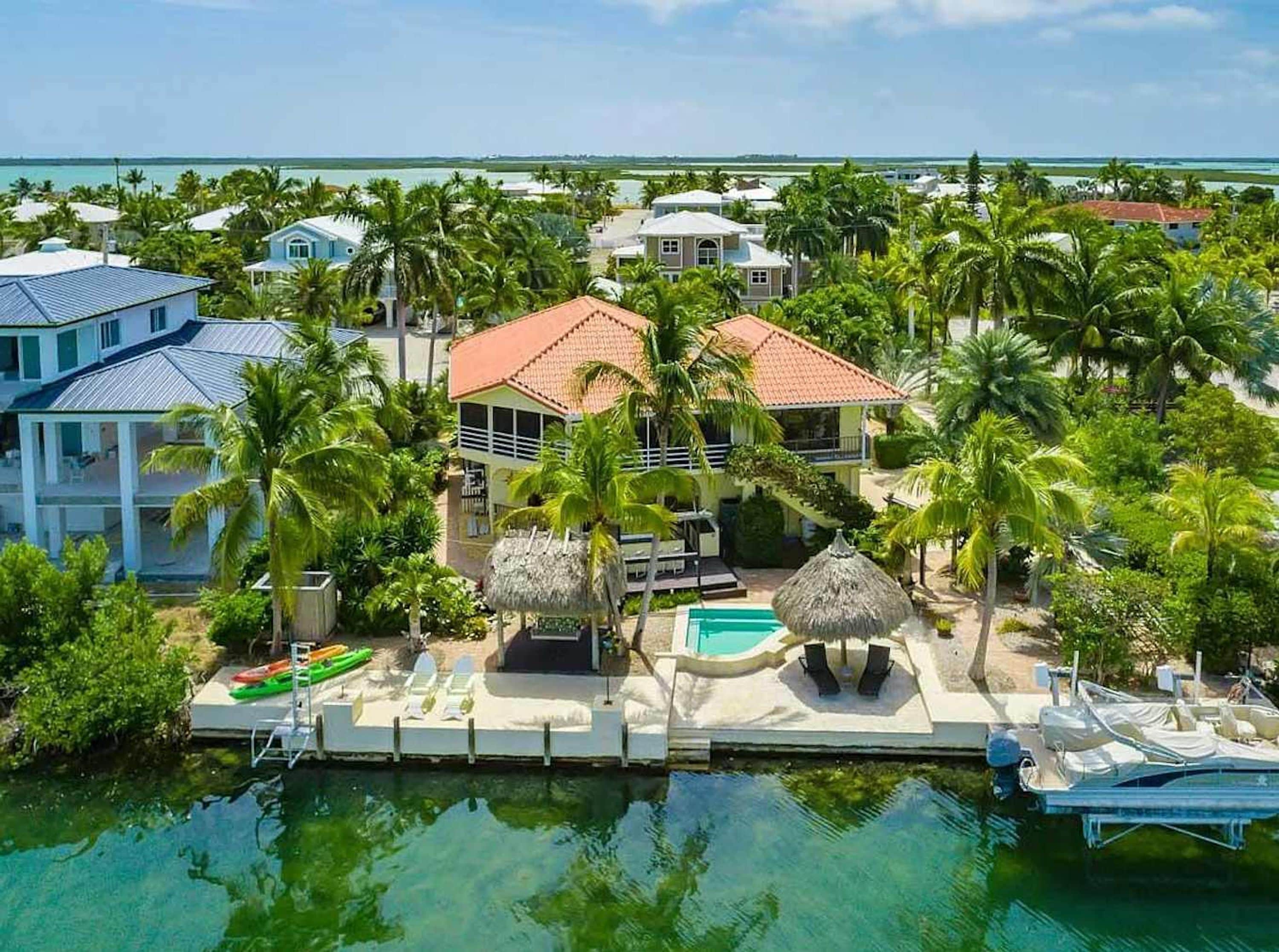 A resort with a pool, lounge chairs, and a view of the ocean.