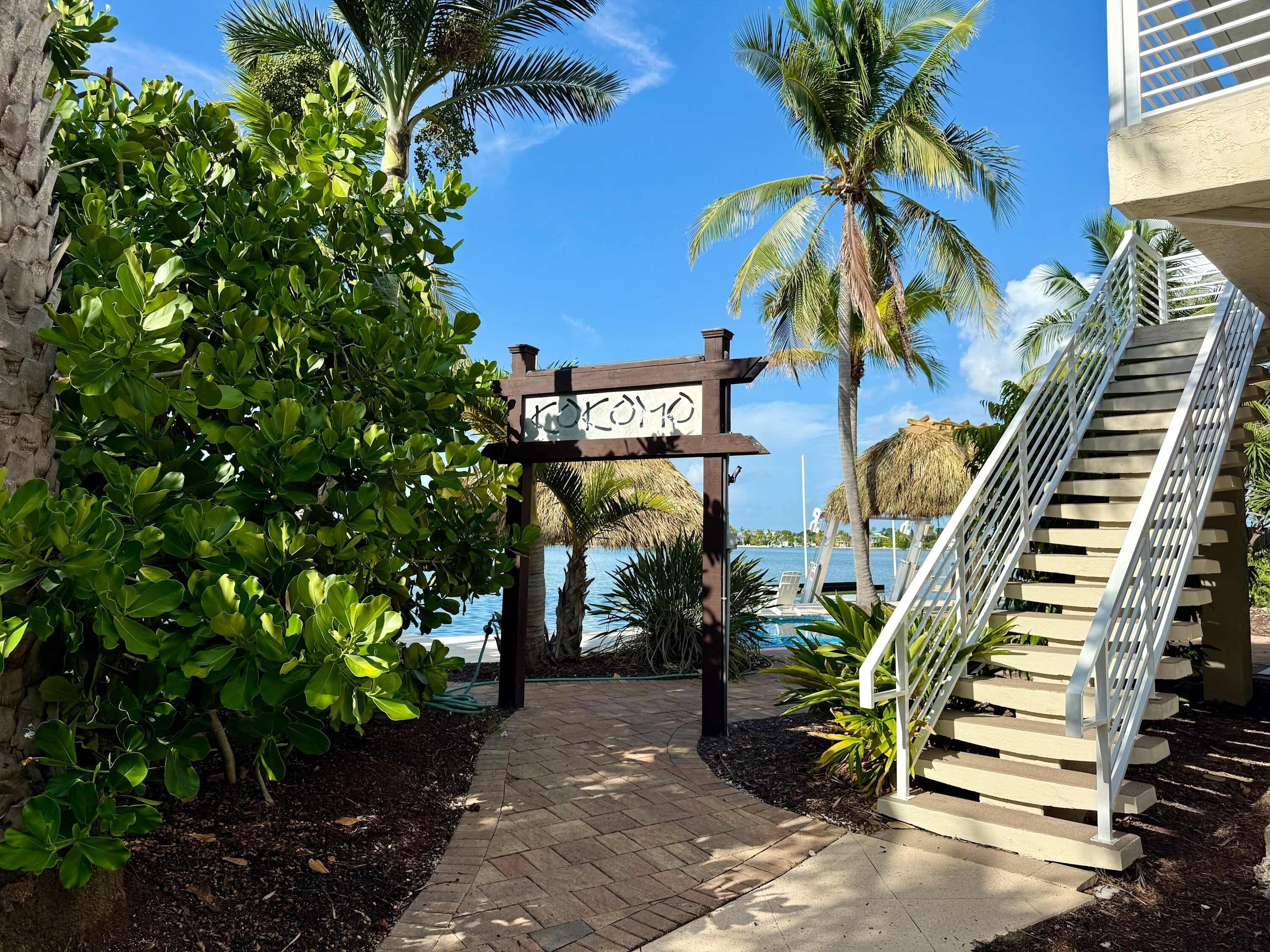 A pathway leading to a building with a staircase on the right.
