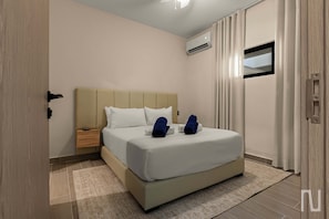 A hotel room with a bed, a nightstand, an air conditioning unit, and a window with curtains. - NOK Modern 1BR Retreat in Panorama Garden (Punta Cana)