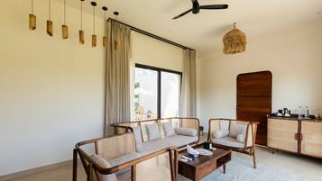 Un salon moderne comprenant un canapé, une table basse et un ventilateur de plafond.