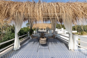 An outdoor patio with a patterned tile floor, a table with chairs, and a pergola with hanging plants. - La Vida Retreat - Luxe 2 Bed Villa in Jaipur (Jaipur)