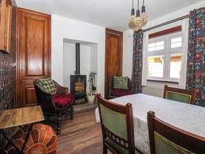 Ein traditionell eingerichtetes Zimmer mit Kamin, Holzmöbeln und einem Esstisch.