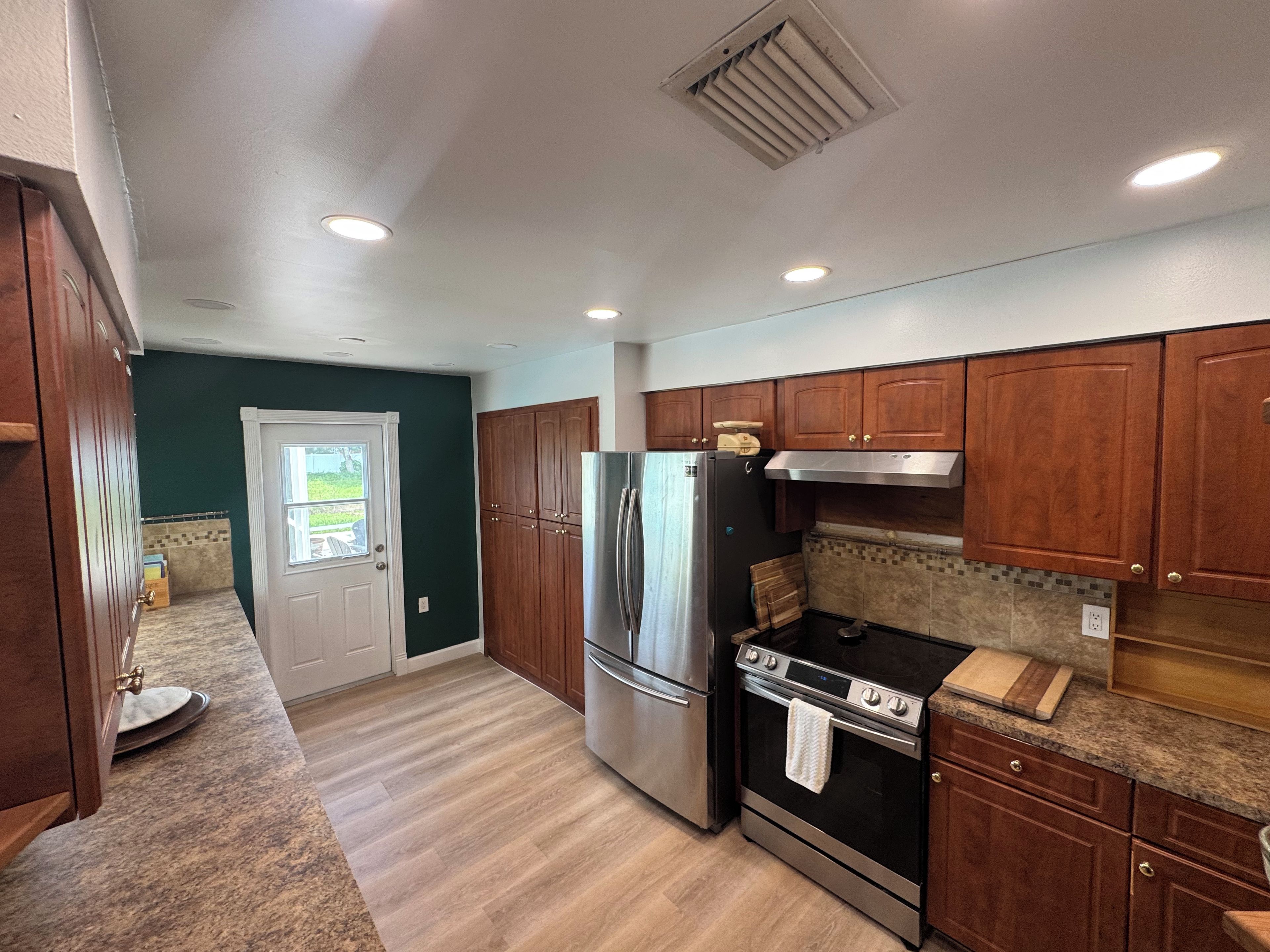 A kitchen with wooden cabinets, stainless steel appliances, and a tiled backsplash.