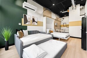 Une chambre d’hôtel moderne, équipée d’un lit, d’une table de chevet et d’un petit coin salon.