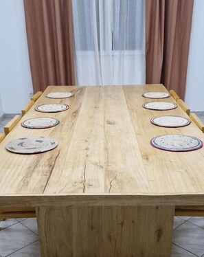 A wooden dining table with eight placemats and a central placemat. - SEED-Aeroport Nsimalen Yaounde (Yaounde)