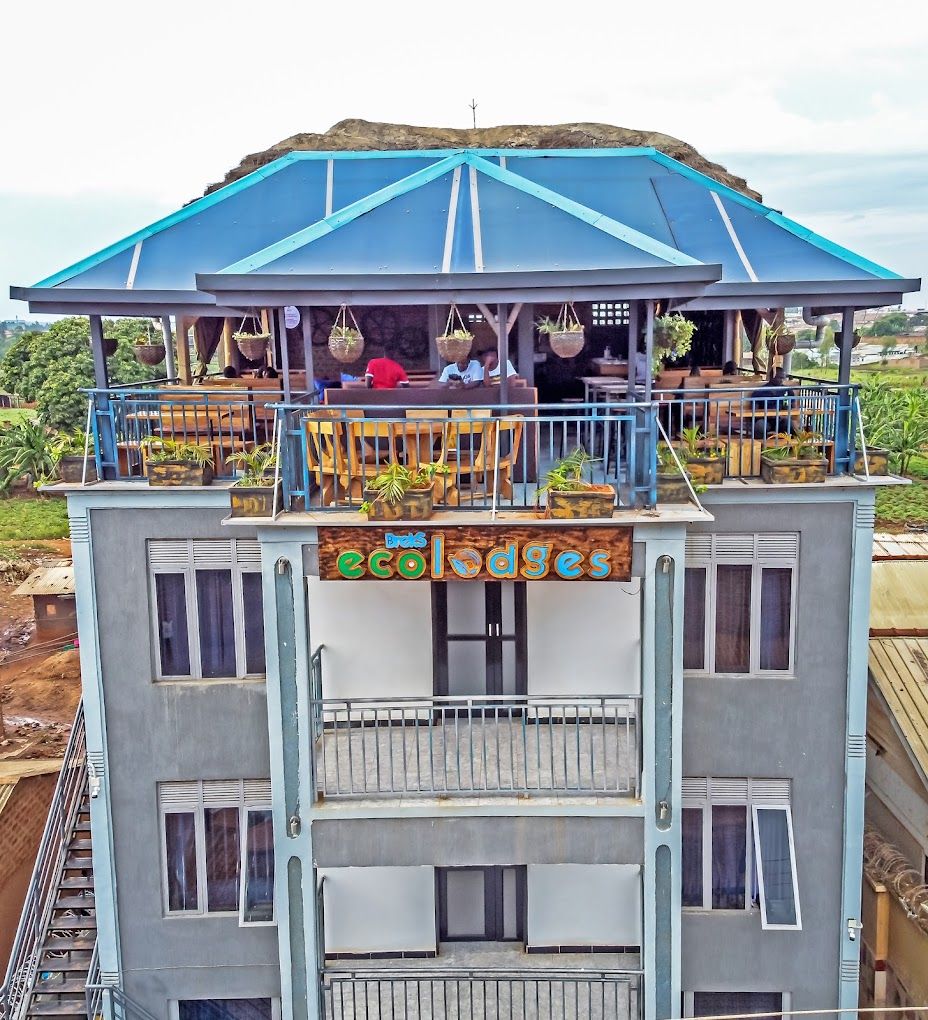 Un edificio de varios pisos con un área de balcón que incluye macetas y mobiliario.